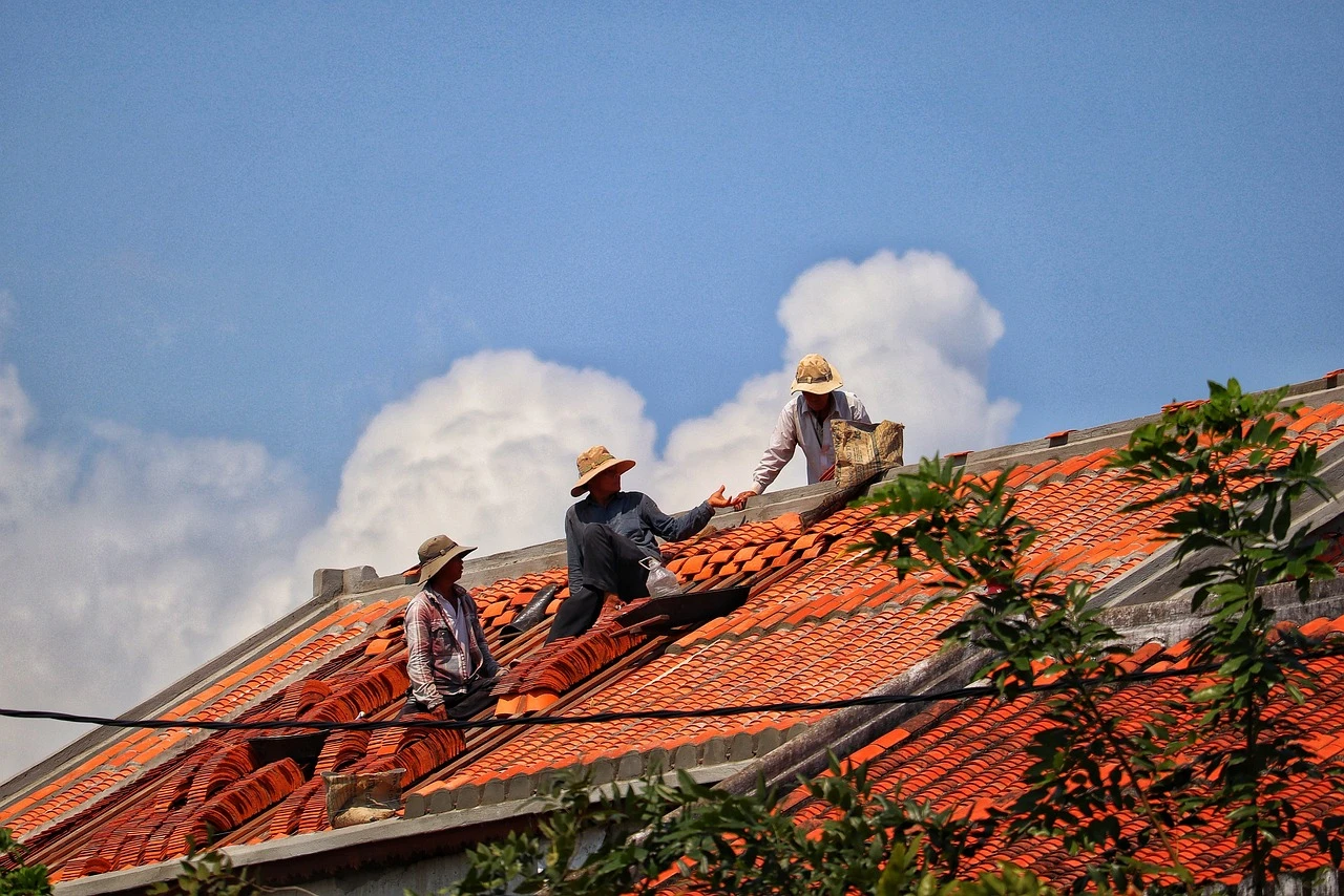 Workers repairing a tiled roof